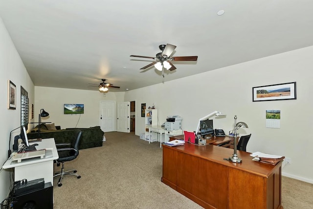 carpeted office space featuring ceiling fan