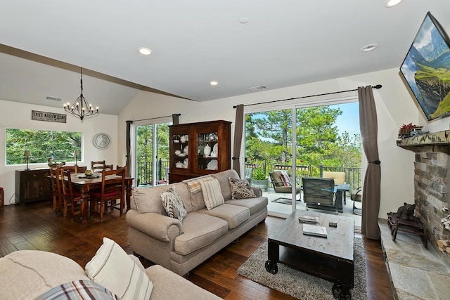 living room featuring lofted ceiling, dark hardwood / wood-style flooring, and a chandelier