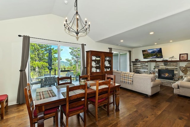 dining room with a fireplace, lofted ceiling, dark hardwood / wood-style floors, and a chandelier