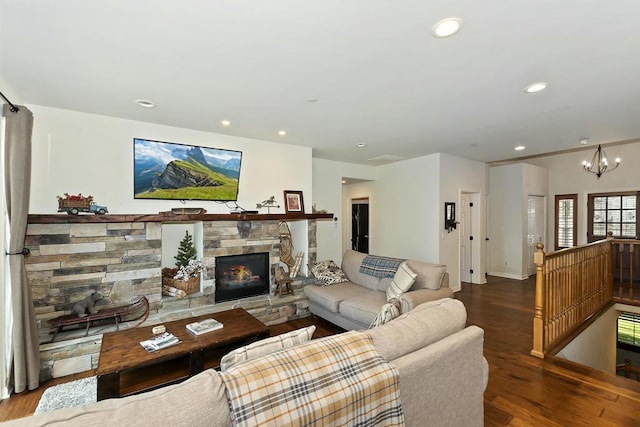 living room featuring an inviting chandelier, a fireplace, and dark hardwood / wood-style floors