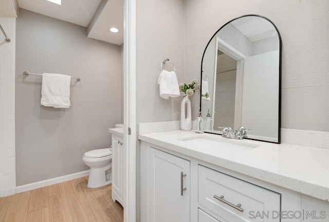 bathroom with vanity, hardwood / wood-style flooring, and toilet