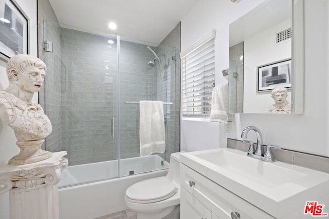 full bathroom with toilet, vanity, and shower / bath combination with glass door