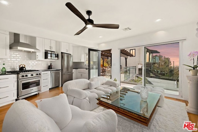 living room with ceiling fan and light wood-type flooring