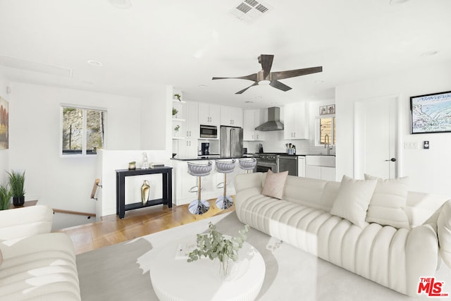 living room featuring ceiling fan and light wood-type flooring