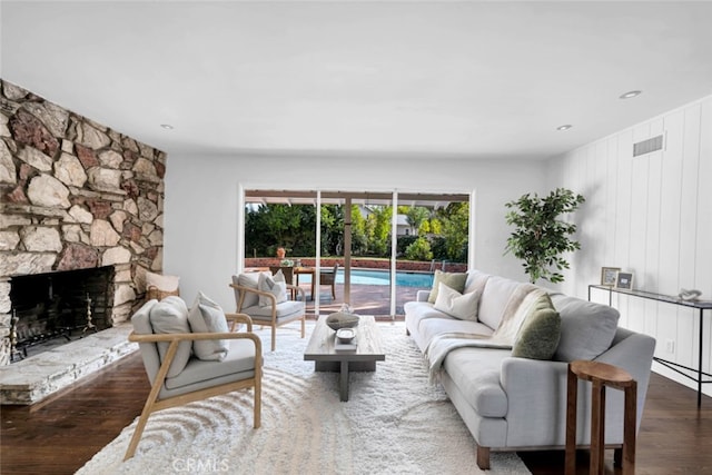 living room featuring a stone fireplace and hardwood / wood-style floors