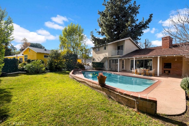 view of pool with a patio and a yard