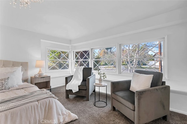 carpeted bedroom featuring multiple windows and a notable chandelier