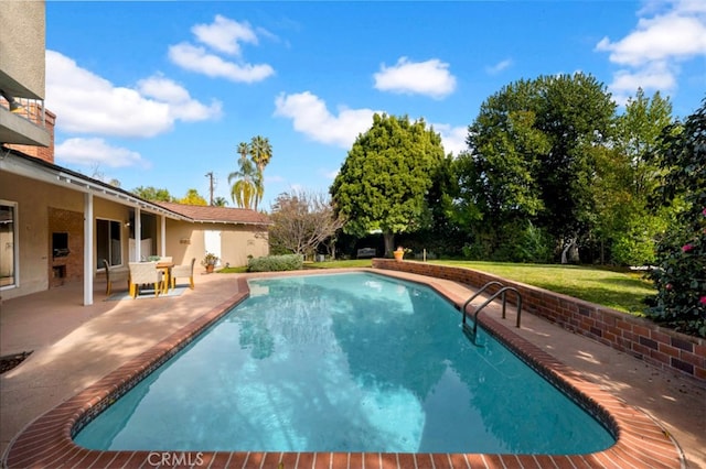 view of pool featuring a lawn and a patio