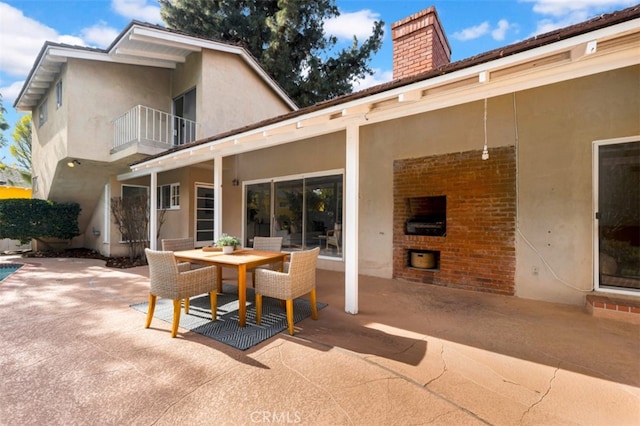 exterior space with a fireplace and a patio