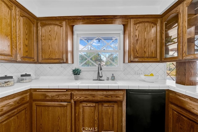 kitchen featuring dishwasher, sink, tile countertops, and backsplash