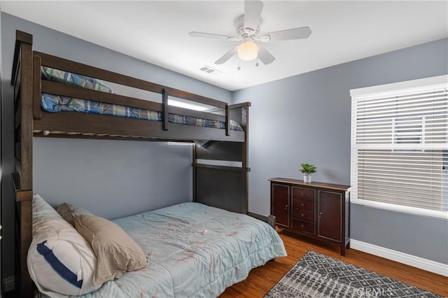 bedroom with hardwood / wood-style flooring, ceiling fan, and multiple windows