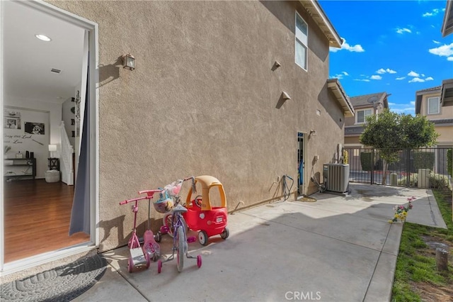 view of property exterior with cooling unit and a patio area