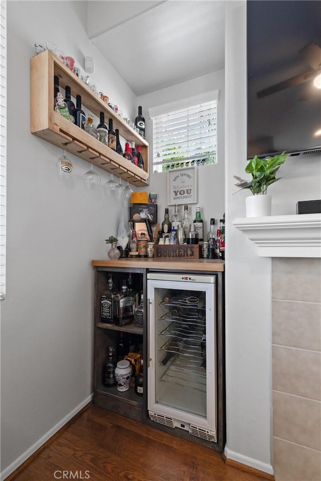 bar with beverage cooler and dark hardwood / wood-style flooring