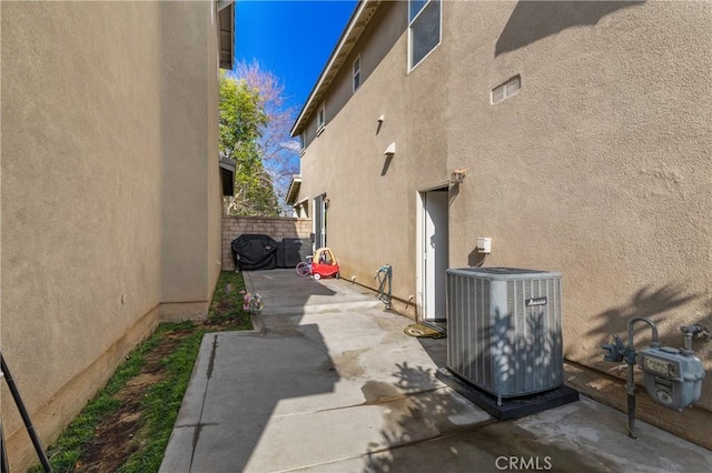 view of property exterior featuring central AC unit and a patio area