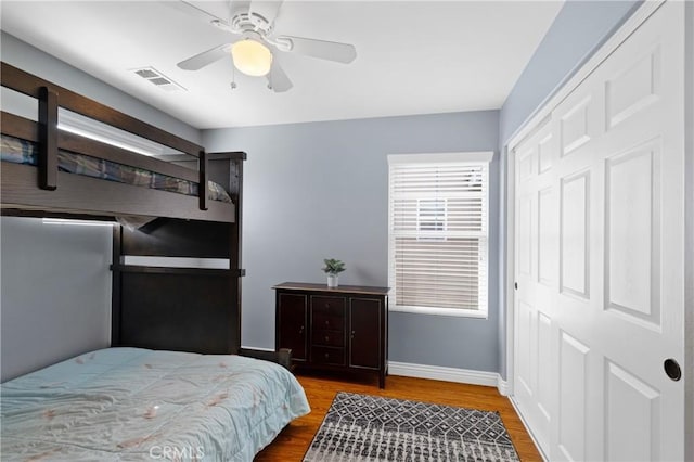 bedroom with hardwood / wood-style floors, ceiling fan, and a closet