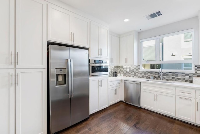 kitchen featuring white cabinetry, appliances with stainless steel finishes, sink, and decorative backsplash