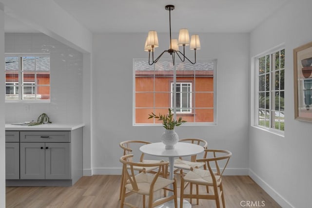 dining room with light hardwood / wood-style flooring and a notable chandelier