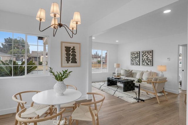 dining room featuring a healthy amount of sunlight, a chandelier, and light hardwood / wood-style flooring