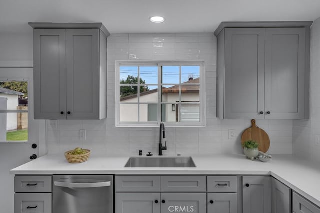 kitchen with gray cabinets, dishwasher, sink, and a wealth of natural light