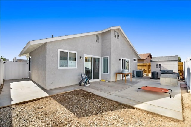 rear view of property with central AC unit and a patio area