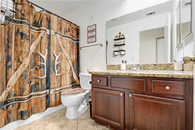 bathroom with tile patterned flooring, vanity, and toilet