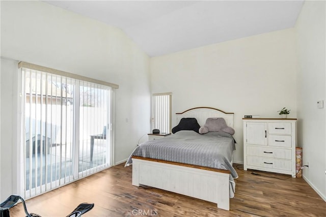 bedroom featuring lofted ceiling, dark hardwood / wood-style floors, and access to exterior