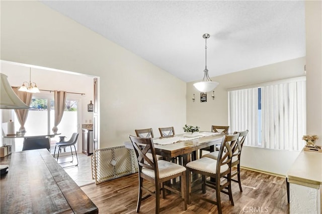 dining space with vaulted ceiling and light hardwood / wood-style floors