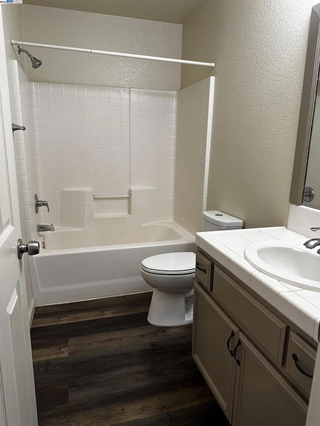 full bathroom featuring wood-type flooring, toilet, tub / shower combination, and vanity