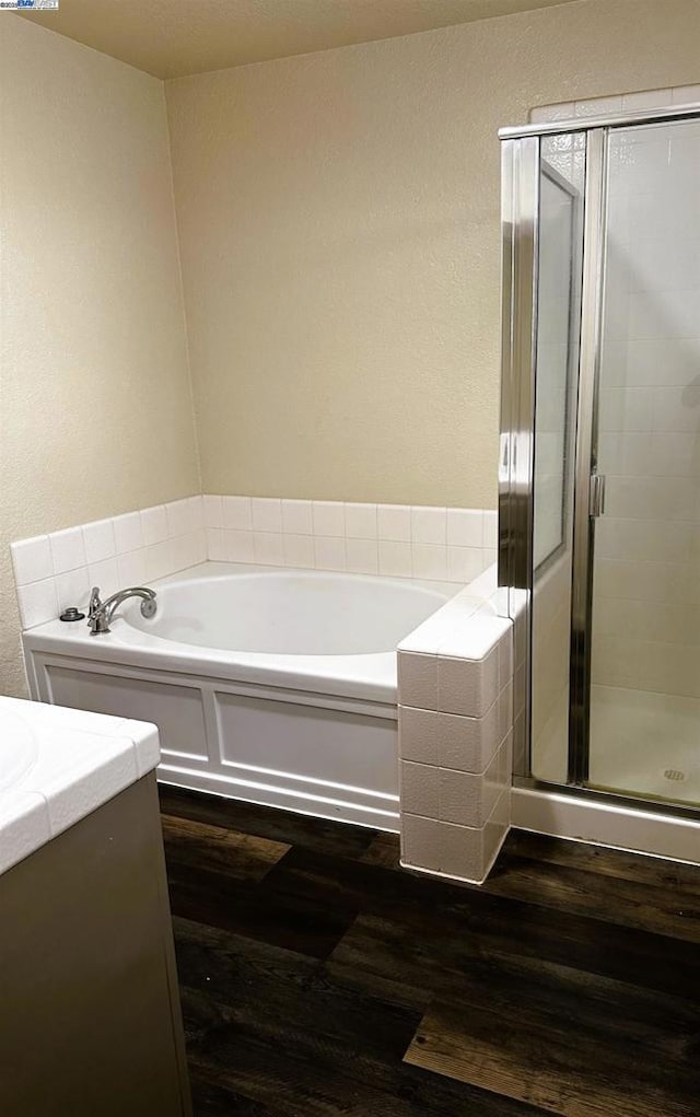 bathroom featuring hardwood / wood-style flooring, vanity, and shower with separate bathtub