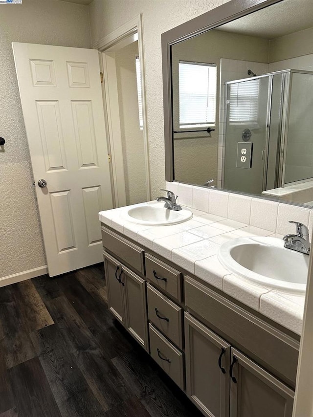 bathroom with vanity, hardwood / wood-style floors, and a shower with door