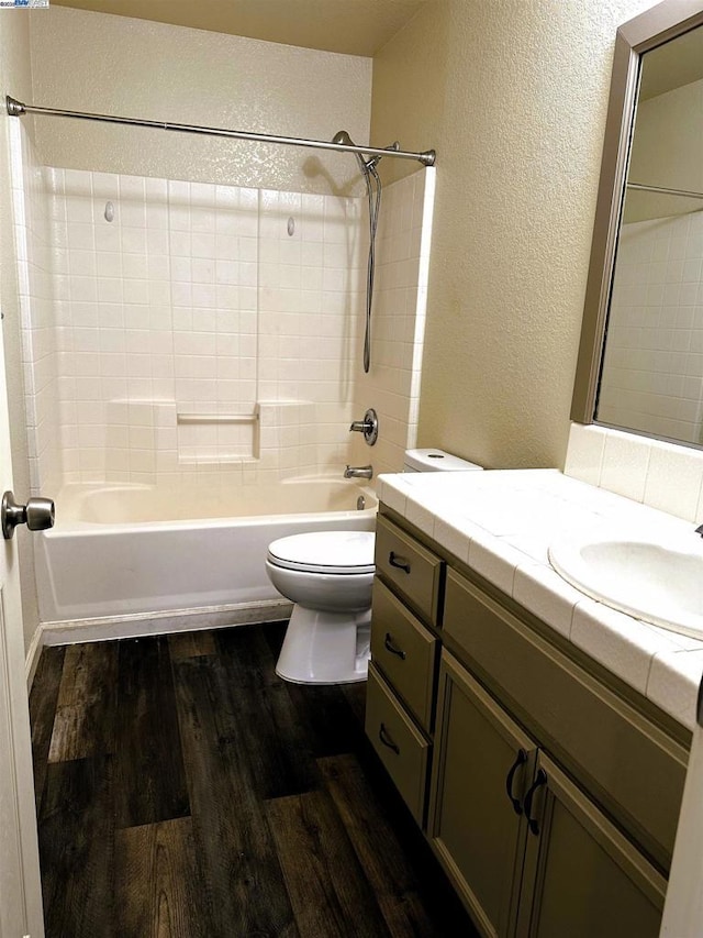 full bathroom featuring vanity, hardwood / wood-style flooring, bathtub / shower combination, and toilet