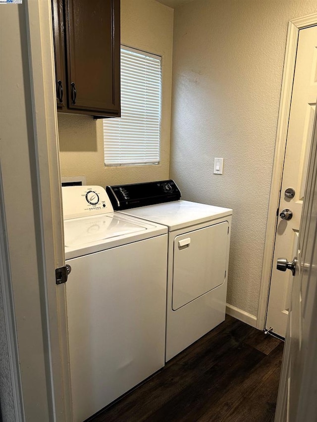 laundry area featuring separate washer and dryer, dark wood-type flooring, and cabinets