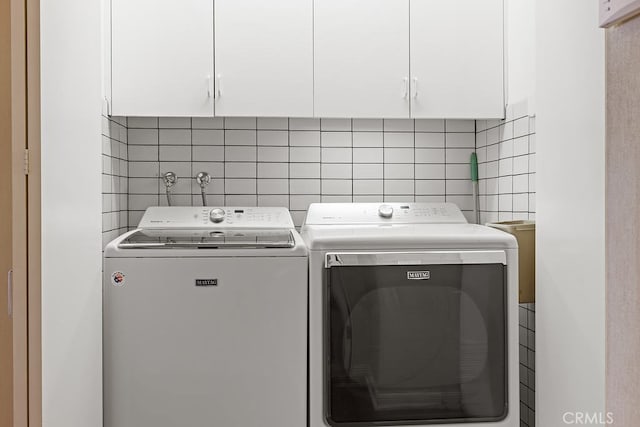 washroom with washer and clothes dryer and cabinets