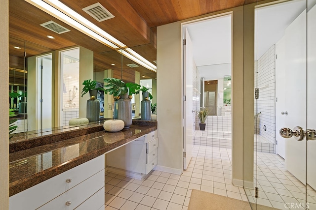 interior space with wood ceiling, dark stone counters, white cabinets, and light tile patterned flooring