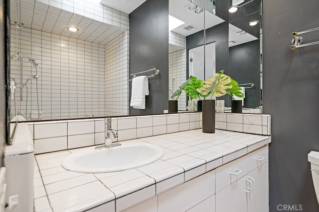 bathroom with vanity, toilet, and decorative backsplash