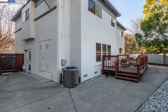 back of property with cooling unit, a deck, and a patio area