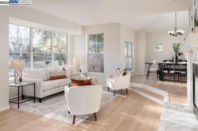 living room with wood-type flooring, plenty of natural light, and a chandelier