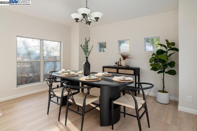 dining area with a notable chandelier and light hardwood / wood-style flooring