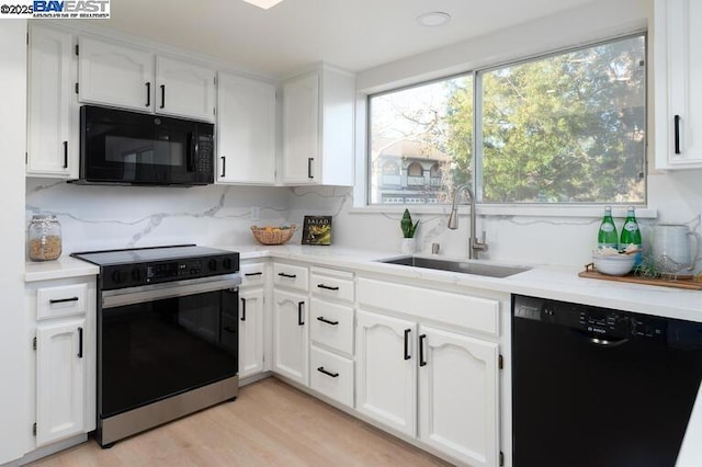 kitchen with sink, white cabinetry, backsplash, black appliances, and light hardwood / wood-style floors