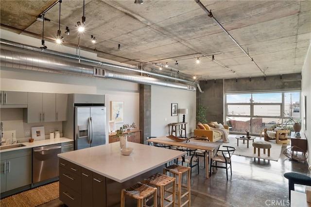 kitchen featuring a sink, light countertops, gray cabinetry, and stainless steel appliances