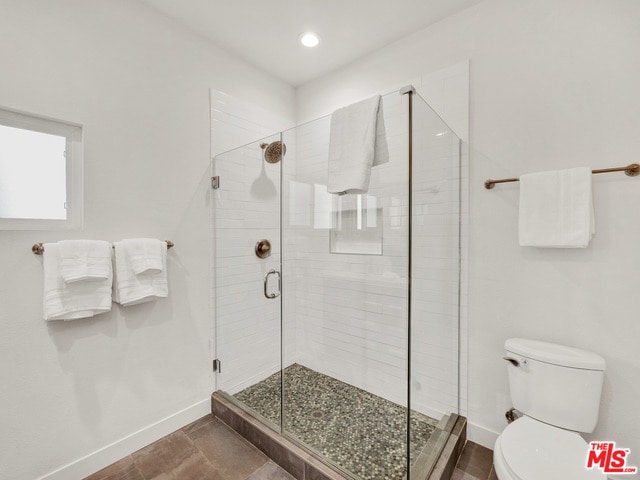 bathroom with toilet and walk in shower