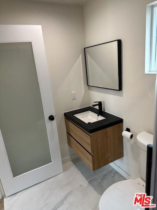 bathroom featuring vanity and toilet