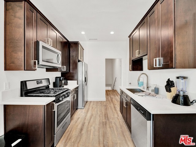 kitchen featuring stainless steel appliances, sink, and dark brown cabinets