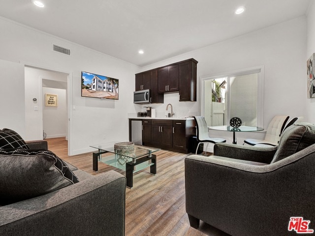 living room with sink and light wood-type flooring