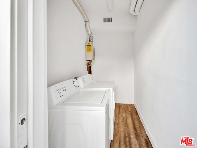 laundry room with hardwood / wood-style flooring and washing machine and clothes dryer