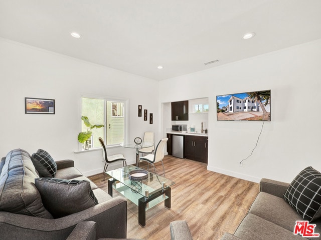 living room featuring sink and light hardwood / wood-style floors