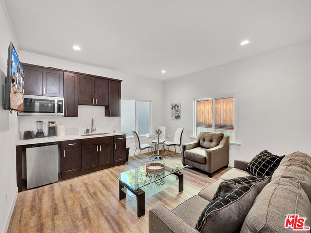 living room with light hardwood / wood-style floors and sink