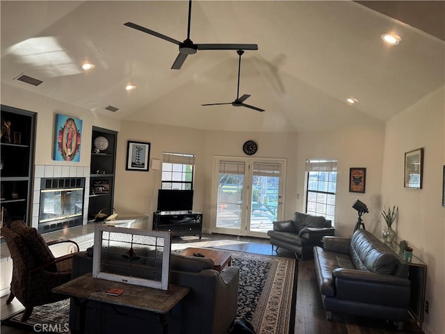 living area with plenty of natural light, visible vents, and a tiled fireplace