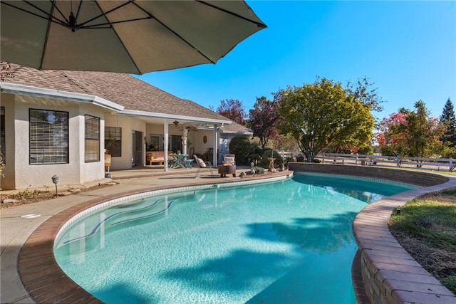 view of swimming pool featuring ceiling fan, a patio, fence, and a fenced in pool