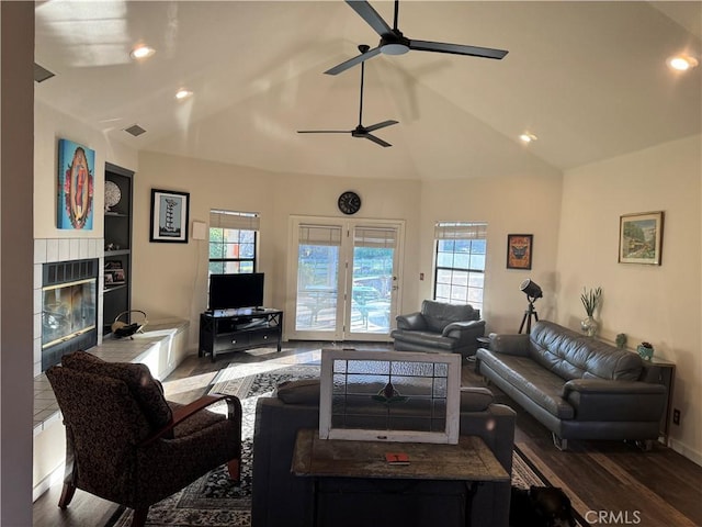 living area featuring a wealth of natural light, lofted ceiling, and visible vents